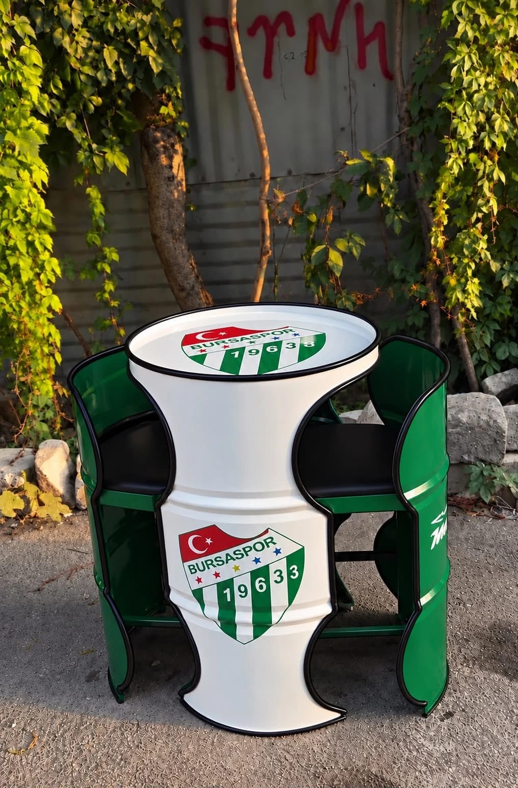 Bursaspor armalı beyaz kum saati kesim varil masa ve iki yeşil varil koltuk, siyah minderli, bahçede