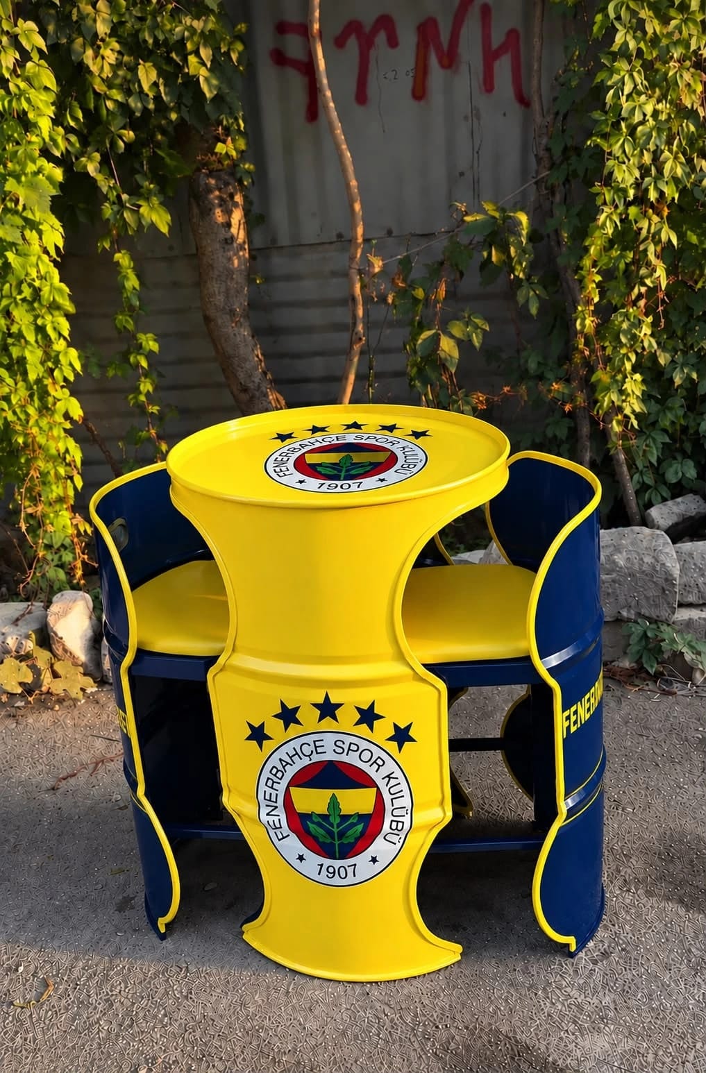Fenerbahçe armalı sarı varil masa ve iki lacivert varil koltuk, sarı minderli, bahçede